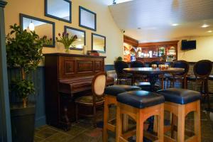 un bar con piano, mesa y sillas en Alcock & Brown Hotel en Clifden