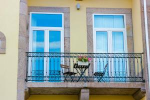 uma varanda com 2 cadeiras e 2 janelas em Oporto Trendy Apartments no Porto