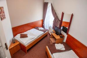 a hotel room with two beds and a television at Penzión Tücsök in Šamorín