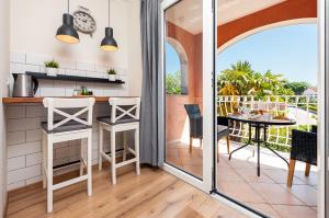 a kitchen with a balcony with a table and chairs at Apartments Villa Istria Rovinj in Rovinj