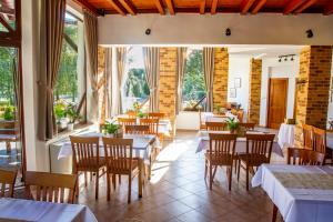 a restaurant with tables and chairs and windows at Penzión Tücsök in Šamorín +17 photos