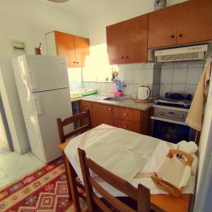 Il comprend une cuisine équipée d'une table et d'un réfrigérateur blanc. dans l'établissement Q Bay Apartments, à Qeparo
