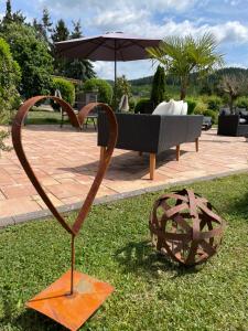 a sculpture of a heart on the grass next to a bench at Maxhof Trier in Trier