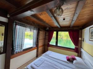 a bed in the back of a train with windows at Rooms and Apartments Neron Bihać in Lohovo