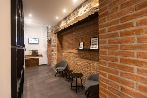 a room with a brick wall and some chairs at Hotel Eladia in Cangas de Onís