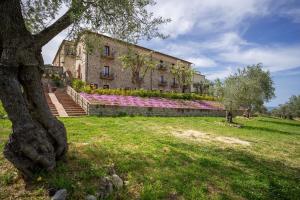 a building with pink flowers on the side of it at Tenuta Ciminata Greco in Rossano