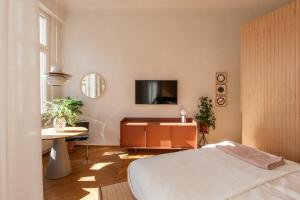 1 dormitorio con 1 cama y TV en la pared en Wyspa 12 en Poznan