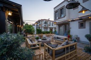 patio z kanapami, stołem i krzesłami w obiekcie Ajlan Hotel Cunda w mieście Ayvalık