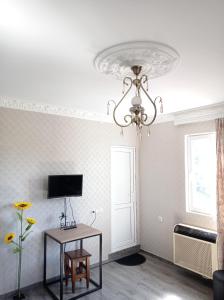 a living room with a chandelier and a table at Home in batumi in Batumi