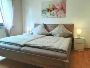 a bedroom with a bed with two lamps on it at Bonnys Ferienwohnung in Nohfelden
