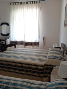 a bedroom with two beds in front of a window at Hotel Parco Delle Rose in Acquappesa