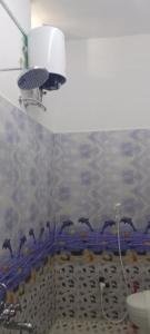 une salle de bain avec un tas de dauphins sur le mur dans l'établissement Chan Maison @ Lakshmi Gardens, à Pondichéry