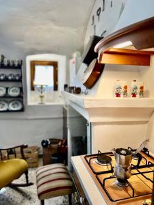 a kitchen with a stove with a pot on it at I Due Gradoni Stone House in Pacentro