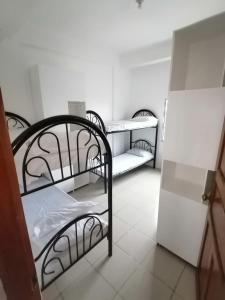 a room with three bunk beds in a room at Two-Hearts Dormitory in Dagupan