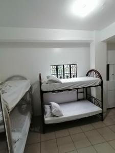 um quarto com 2 beliches e uma janela em Two-Hearts Dormitory em Dagupan