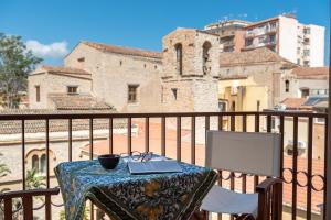 a table with a laptop on top of a balcony at La Paperella Blu Apartment in Termini Imerese