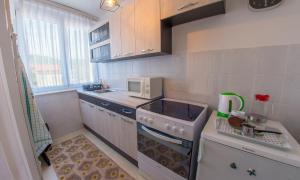 a small kitchen with a stove and a microwave at Apartment Revia in Mostar