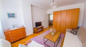 una sala de estar con un sofá y una mesa en Apartment Revia, en Mostar
