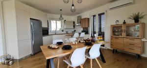 een keuken met een houten tafel en witte stoelen bij Villa Arianna, il piacere di vivere nella natura. in Alcamo