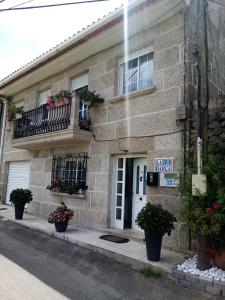 a stone building with potted plants in front of it at Apartamento Tui, Casa da Barca in Tui