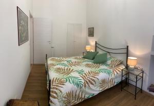 a bedroom with a bed with a green and white comforter at Circus Maximus n.2 - At 400m Metro in Rome