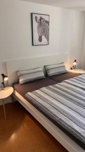 Apartment near Europa-Park & Black Forest في كابل غرافنهاوسن: غرفة نوم مع سرير مع صورة لحمار الوحشي