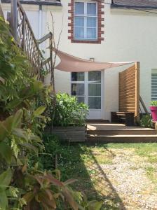 ein Haus mit einer Veranda mit einer Hängematte im Hof in der Unterkunft Erdre Rivière Climatisé in La Chapelle-sur-Erdre
