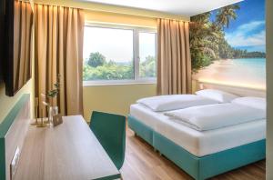 a bedroom with two beds and a table and a window at Hi5-Hotel Seiersberg in Windorf