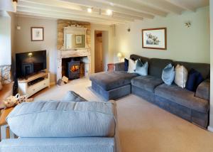 un soggiorno con divano e camino di Cosy cottage Blockley, Cotswolds - Squire Cottage a Blockley