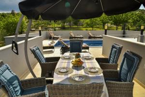 a table and chairs on a patio with an umbrella at Luxury Villa Rebecca in Gornji Muć