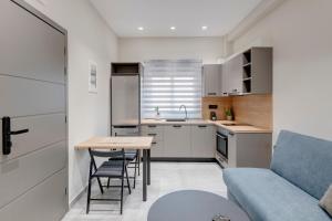a small kitchen with a table and a blue couch at Argento urban apartments (cube) in Ermoupoli