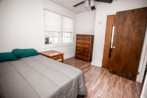 a bedroom with a bed and a dresser and a window at HISTORIC HILL APARTMENTS (Duplex) in Tuskegee