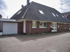 a red brick house with a white garage at Lagunen Bude in Büsum