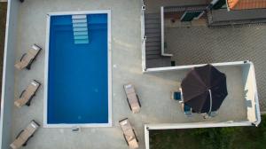 an overhead view of a swimming pool with an umbrella at Luxury Villa Rebecca in Gornji Muć