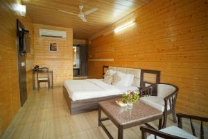 1 dormitorio con 1 cama, mesa y sillas en Comfort Inn Coral River, en Mādhopur