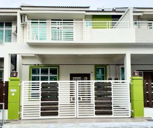 a white fence in front of a house at Green Homestay Tangga Batu in Tangga Batu