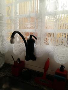 a kitchen sink with a faucet next to a window at Casa agradavel com churrasqueira no centro de Serra Negra in Serra Negra