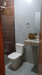 a bathroom with a white toilet and a counter at Casa Antiga Hospedagem - Taipu de Fora in Barra Grande
