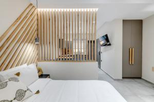 a bedroom with a bed and a large window at Argento urban apartment (sphere) in Ermoupoli