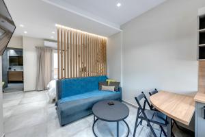 a living room with a blue couch and a table at Argento urban apartment (sphere) in Ermoupoli