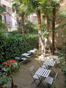 un grupo de sillas y mesas blancas en un patio en La Casa della Zia, en Milán