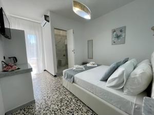 a white bedroom with a bed and a bathroom at B&B Poesia in Gallipoli