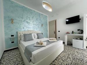 a bedroom with a large white bed with a blue wall at B&B Poesia in Gallipoli