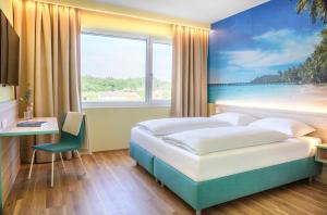 una camera d'albergo con un letto e una grande finestra di Hi5-Hotel Seiersberg a Windorf Altre 37 foto