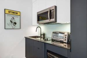 una cocina con fregadero y microondas en INITIAL - MONOPOLY - Centre-Ville de Quebec, en Quebec