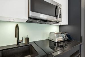 cocina con microondas y encimera con fregadero en INITIAL - MONOPOLY - Centre-Ville de Quebec, en Quebec 22 fotos más