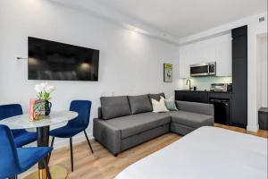 una sala de estar con un sofá, una mesa y sillas en INITIAL - MONOPOLY - Centre-Ville de Quebec, en Quebec