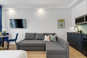 sala de estar con sofá gris y cocina en INITIAL - MONOPOLY - Centre-Ville de Quebec, en Quebec