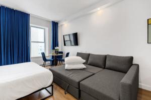 una sala de estar con un sofá y una cama en INITIAL - MONOPOLY - Centre-Ville de Quebec, en Quebec