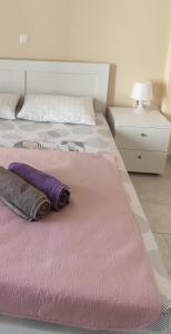 - un lit rose avec deux oreillers en dessus dans l'établissement Comfort apartment for small family, à Loutraki